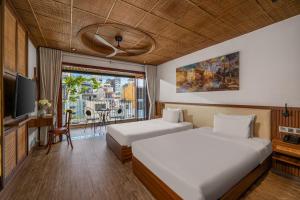 a hotel room with two beds and a balcony at LUK Inn Hotel - An Thuong, Da Nang in Danang +37 photos