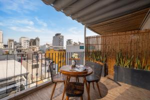 a balcony with a table and chairs and a view of a city at LUK Inn Hotel - An Thuong, Da Nang in Danang