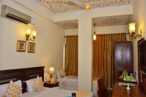 a hotel room with a bed and a table and a couch at Rajputana Haveli in Jaipur