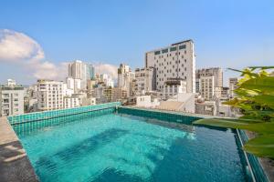 a swimming pool on top of a building with a city at LUK Inn Hotel - An Thuong, Da Nang in Danang