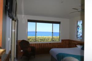 a bedroom with a bed and a window with a view at Bunkys By The Sea Holiday House in Berrara