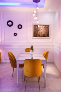 a dining room with a table and yellow chairs at The View Apartments Salagi in Brusubi