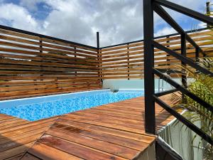 a deck with a swimming pool and a wooden fence at Live bambu in Caimital
