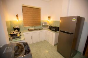 a kitchen with a refrigerator and a microwave at The Lux Villa in Habaraduwa Central