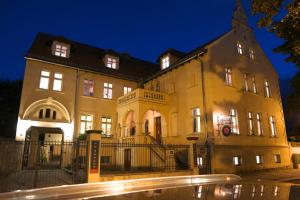 een groot gebouw 's nachts met een straat bij Villa Le Palais Quedlinburg in Quedlinburg