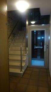 a hallway with a staircase with a door and a stair case at Apartamento con balcón in Viveiro