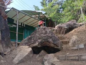 a large rock sitting in front of a building at Sinharaja-Forest Cave Camp in Ullinduwawa