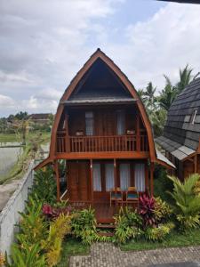 a wooden house with a gambrel roof at Kayu Joglos Ubud in Ubud