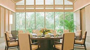 a dining room with a table and chairs and a large window at 四川成都金牛宾馆 Sichuan State Guest Hotel in Chengdu