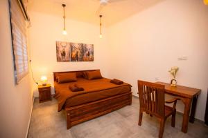 a bedroom with a bed and a desk in it at The Lux Villa in Habaraduwa Central
