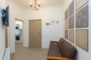 a living room with a couch and a wall with pictures at Mais Guest House in Tbilisi City