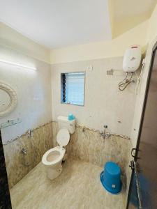 a bathroom with a toilet and a window in it at Between The Raindrops in Lonavala +9 photos