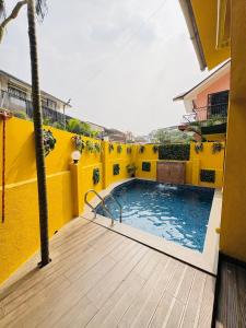 a yellow building with a swimming pool on a balcony at Between The Raindrops in Lonavala