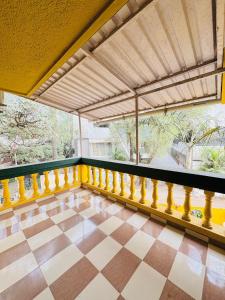 a balcony with a yellow railing and a tiled floor at Between The Raindrops in Lonavala