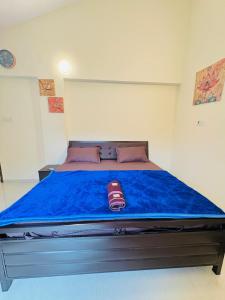 a bedroom with a large bed with a blue blanket at Between The Raindrops in Lonavala