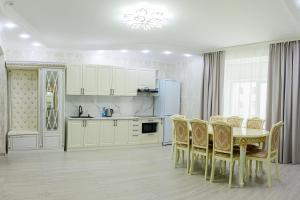 a white kitchen with a table and chairs at Гостиница Караганда in Karagandy