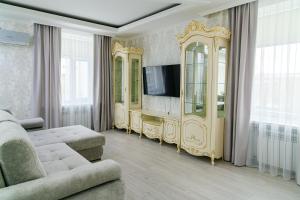 a living room with a tv and a couch and a mirror at Гостиница Караганда in Karagandy