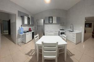 a kitchen with a white table and chairs in it at Casa Refúgio Tamandaré in Tamandaré