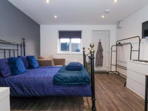a bedroom with a bed with a blue comforter at Chalet 1 in Ganton