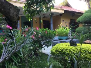 un jardín frente a una casa con flores rosas en Villa Taman Ayu, en Tejakula