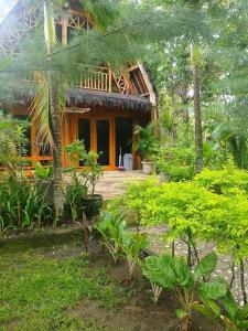 a house with a lot of plants in front of it at Triple J Villa in Sekongkang Bawa