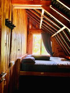 a bedroom with a bed in a wooden cabin at Triple J Villa in Sekongkang Bawa