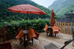 a table and chairs with an umbrella on a deck at Albergo La Pace in Pradleve