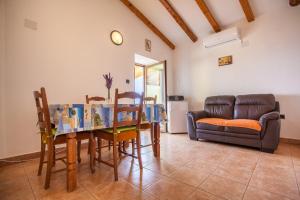 a living room with a table and chairs and a couch at Apartment Vidovići in Martinšćica