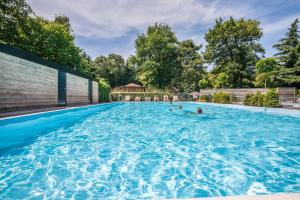 a swimming pool with people in the water at Bungalowpark Het Verscholen Dorp in Harderwijk