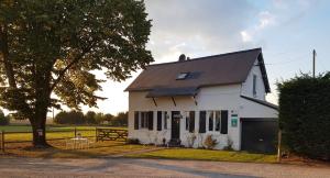 uma casa branca com uma árvore e uma cerca em Le Grand Gîte em Dorengt