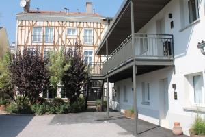 an apartment building with a balcony on the side of it at Hôtel jardin Le Pasteur in Châlons-en-Champagne