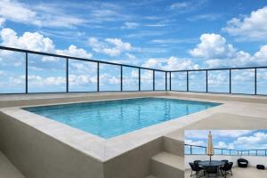 a swimming pool on top of a building at PISCINA, 2qts, 2 banh, varanda c churrasqueira, estacionamento, elevador, portaria in São Lourenço