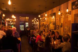 a group of people sitting at tables in a restaurant at Guesthouse Vakantie Logies Hollywood in Bruges