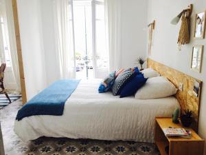 a bedroom with a large bed with blue pillows at L´arrière Cour in Cancale