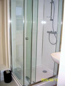 a shower with a glass door in a bathroom at Luxury Apartment at Barron House in Nairn