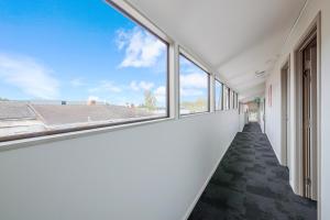 an empty corridor with windows in a building at Greenlane Motel in Auckland