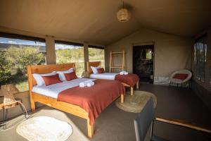 a bedroom with two beds in a tent at Entalet Mara Camp in Talek