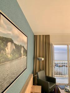 a room with a chair and a large painting on the wall at RÜGEN-HOTEL mit Ostseeblick in Sassnitz