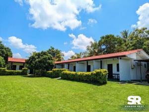 a building with a grass yard in front of it at Samren Rest in Hambantota +5 photos