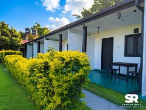 a house with a green hedge in front of it at Samren Rest in Hambantota