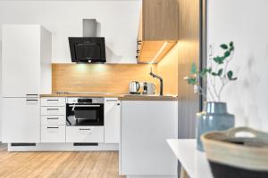 a kitchen with a stove and a microwave at Apartmány BD Boží Dar by Mountain ways in Boží Dar