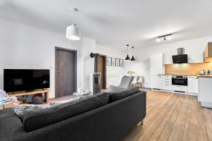 a living room with a couch and a kitchen at Apartmány BD Boží Dar by Mountain ways in Boží Dar