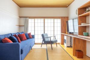 a living room with a blue couch and a chair at Vaisala in Nozawa Onsen