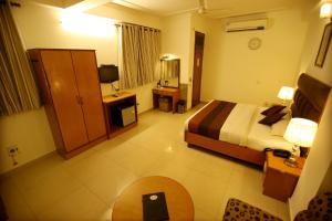 Habitación de hotel con cama y TV en Hotel Parkway Deluxe, en Nueva Delhi