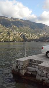 een witte auto geparkeerd naast een lichaam water bij Apartment Radovic in Kotor