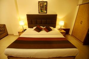 a hotel room with a large bed with two lamps at Hotel Parkway Deluxe in New Delhi