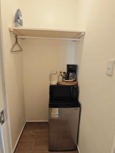 a small refrigerator in a hallway with a shelf at Comfy Habitación en Puebla! in San Baltasar
