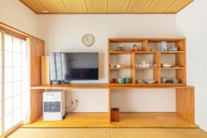 a living room with a tv and a shelf at Vaisala in Nozawa Onsen +34 photos