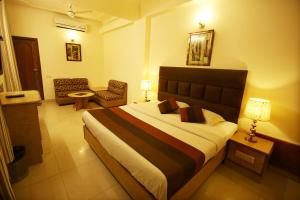 Habitación de hotel con cama y silla en Hotel Parkway Deluxe, en Nueva Delhi