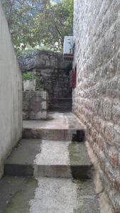 an alley with a stone wall and a red door at Apartment Radovic in Kotor